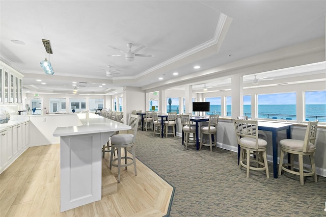 3315 S Atlantic Ave Unit 1605, Daytona Beach Shores, FL 32118 - kitchen featuring ornamental molding, a tray ceiling, a ceiling fan, recessed lighting, and a breakfast bar