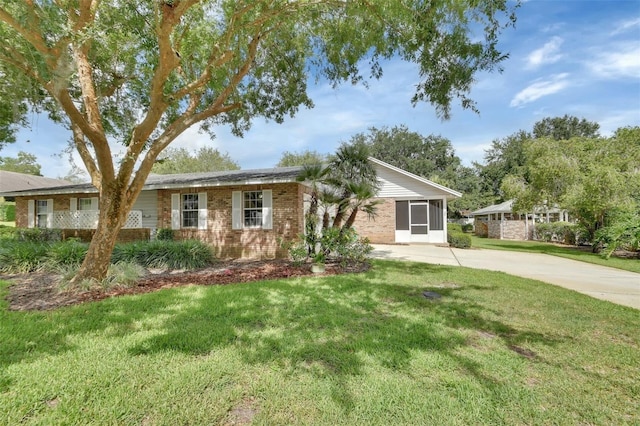 2480 S Glen Eagles Dr, Deland, FL 32724 - ranch-style house with brick siding, concrete driveway, and a front lawn