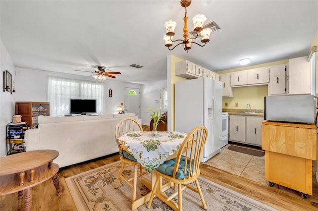 2468 Kimberly Dr, Deltona, FL 32738 - dining room featuring light wood finished floors, a chandelier, and ceiling fan