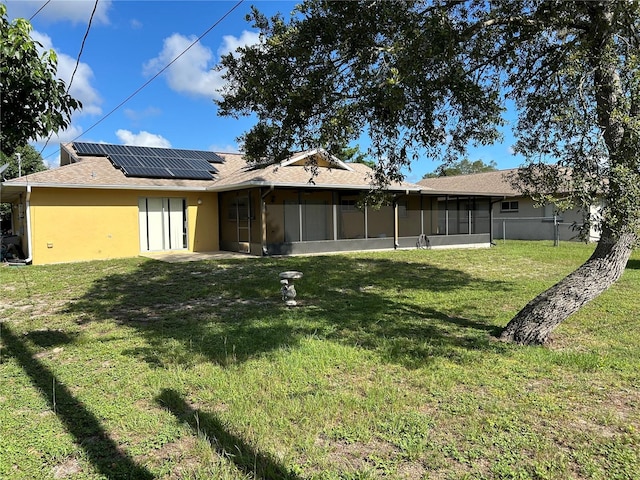 1887 Viking Ave, Deltona, FL 32725 - rear view of house featuring a sunroom, roof mounted solar panels, a yard, and stucco siding
