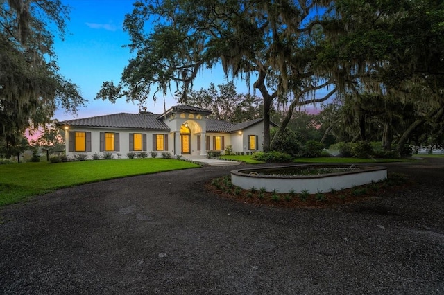 4885 State Road 11, De Leon Springs, FL 32130 - mediterranean / spanish house with a yard, a tiled roof, curved driveway, and stucco siding