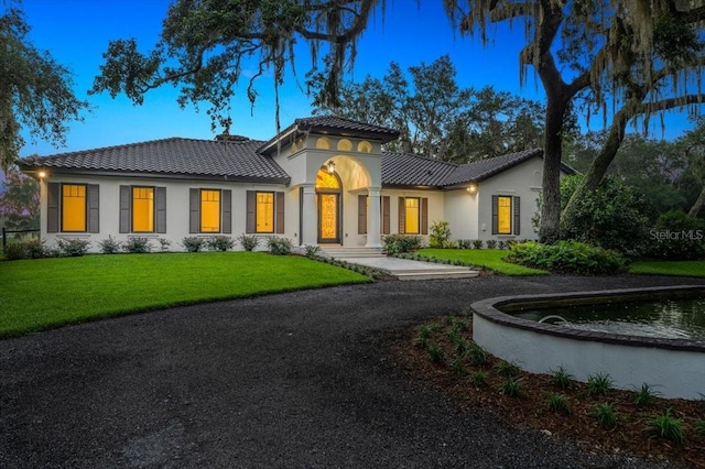 4885 State Road 11, De Leon Springs, FL 32130 - mediterranean / spanish house with a tiled roof, a front yard, and stucco siding