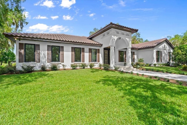 4885 State Road 11, De Leon Springs, FL 32130 - mediterranean / spanish house with a tile roof, a front lawn, and stucco siding