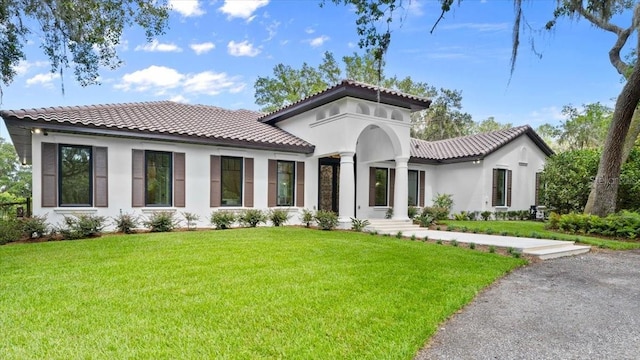 4885 State Road 11, De Leon Springs, FL 32130 - mediterranean / spanish-style home featuring a tiled roof, a front yard, and stucco siding