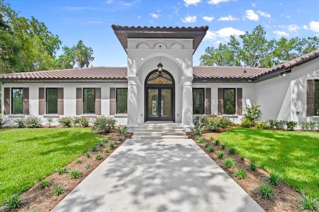 4885 State Road 11, De Leon Springs, FL 32130 - view of front of house with stucco siding, a tiled roof, a front yard, and french doors
