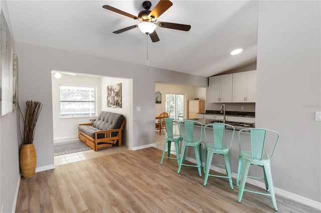 5 Bird Of Paradise Pl, Palm Coast, FL 32137 - kitchen featuring a breakfast bar, dark countertops, plenty of natural light, ceiling fan, and lofted ceiling
