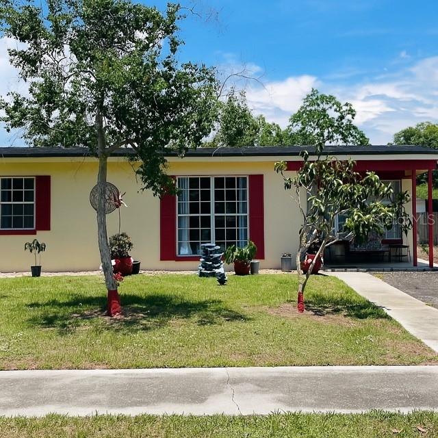 1025 Persian St, Deltona, FL 32725 - ranch-style house with a front yard and stucco siding