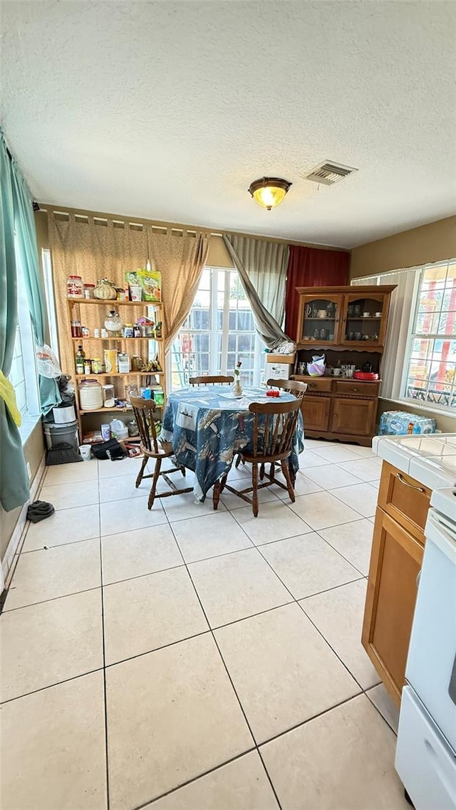 1025 Persian St, Deltona, FL 32725 - dining space featuring a textured ceiling, plenty of natural light, and light tile patterned floors