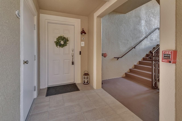 424 Luna Bella Ln Unit 330, New Smyrna Beach, FL 32168 - foyer featuring stairway, tile patterned floors, and a textured wall