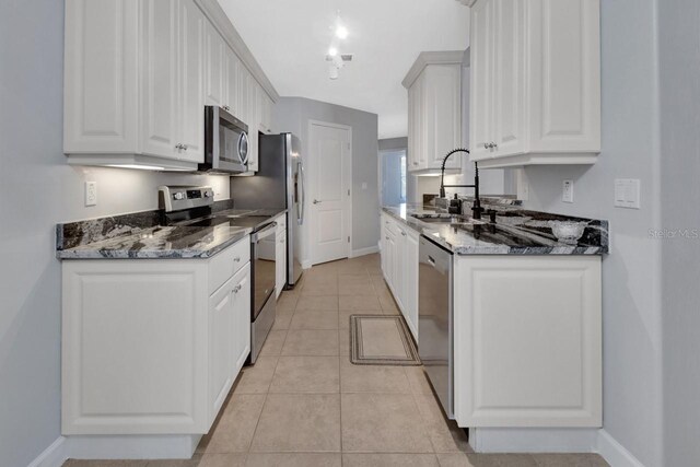 424 Luna Bella Ln Unit 330, New Smyrna Beach, FL 32168 - kitchen with appliances with stainless steel finishes, white cabinets, light tile patterned floors, and dark stone countertops