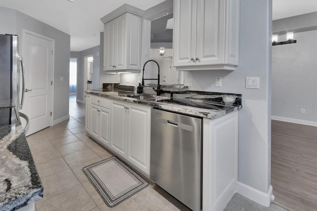 424 Luna Bella Ln Unit 330, New Smyrna Beach, FL 32168 - kitchen featuring appliances with stainless steel finishes, white cabinetry, stone countertops, and light tile patterned floors