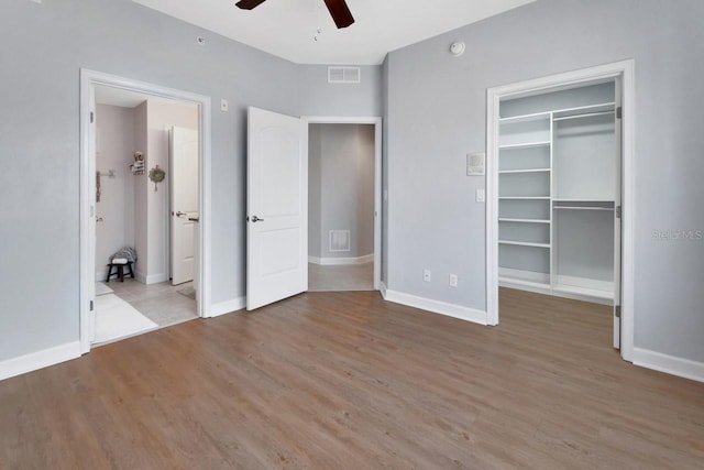 424 Luna Bella Ln Unit 330, New Smyrna Beach, FL 32168 - unfurnished bedroom featuring wood finished floors, a spacious closet, a closet, and a ceiling fan