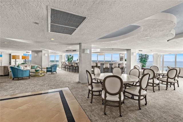 2545 S Atlantic Ave Unit 102, Daytona Beach Shores, FL 32118 - carpeted dining area with inlaid floor details, healthy amount of natural light, and a textured ceiling