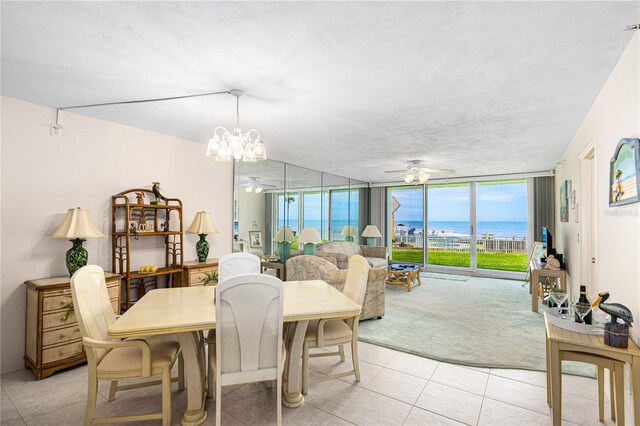2545 S Atlantic Ave Unit 102, Daytona Beach Shores, FL 32118 - dining area featuring ceiling fan, a water view, light tile patterned flooring, a textured ceiling, and light colored carpet