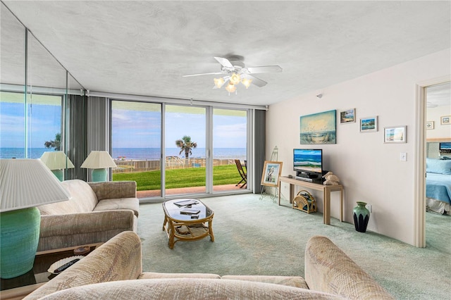 2545 S Atlantic Ave Unit 102, Daytona Beach Shores, FL 32118 - carpeted living area with ceiling fan, a water view, and expansive windows