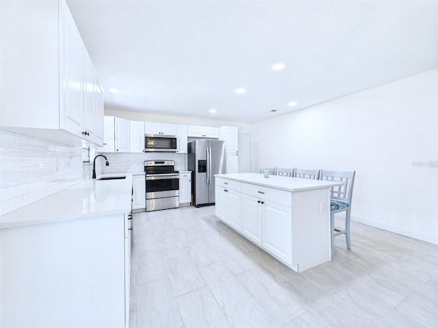 2526 Victory Palm Dr, Edgewater, FL 32141 - kitchen featuring appliances with stainless steel finishes, a center island, tasteful backsplash, white cabinets, and recessed lighting