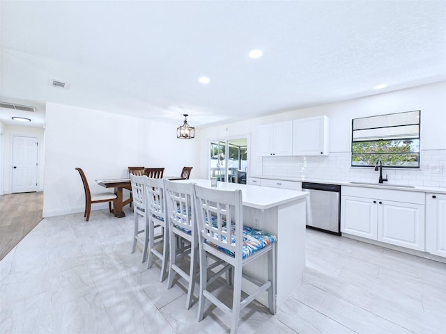 2526 Victory Palm Dr, Edgewater, FL 32141 - kitchen with stainless steel dishwasher, light countertops, white cabinets, tasteful backsplash, and recessed lighting