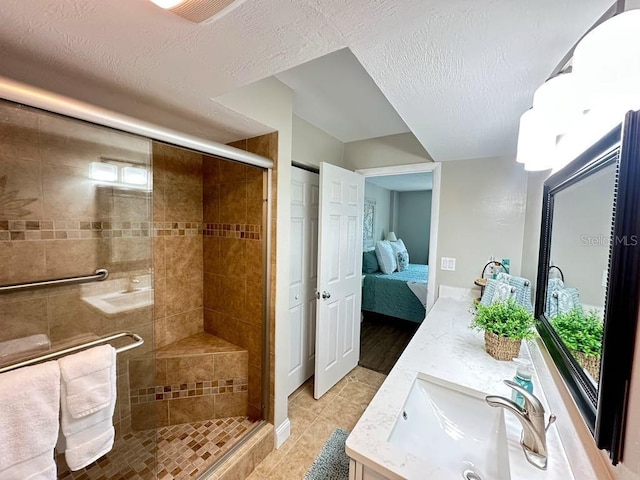 2860 Ocean Shore Blvd Unit 5020, Ormond Beach, FL 32176 - bathroom featuring double vanity, a shower stall, connected bathroom, a textured ceiling, and tile patterned floors