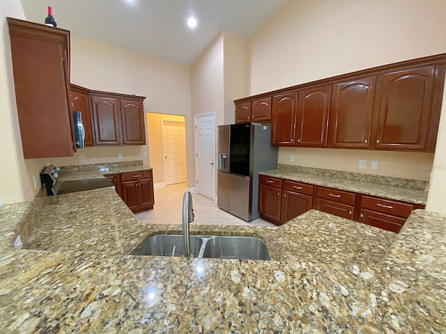 19320 Oberly Pkwy, Orlando, FL 32833 - kitchen with stainless steel refrigerator with ice dispenser, electric stove, light stone counters, high vaulted ceiling, and light tile patterned floors