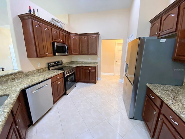 19320 Oberly Pkwy, Orlando, FL 32833 - kitchen featuring stainless steel appliances, light stone countertops, and light tile patterned floors