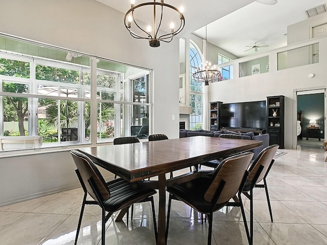 5936 Boggs Ford Rd, Port Orange, FL 32127 - dining area with a chandelier, ceiling fan, light tile patterned floors, and a towering ceiling