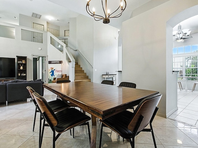 5936 Boggs Ford Rd, Port Orange, FL 32127 - dining room with a chandelier, stairway, a towering ceiling, arched walkways, and light tile patterned floors