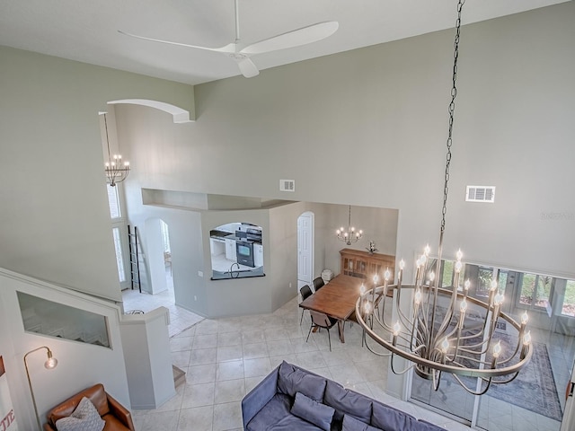 5936 Boggs Ford Rd, Port Orange, FL 32127 - entrance foyer featuring arched walkways, a towering ceiling, ceiling fan, tile patterned flooring, and a chandelier