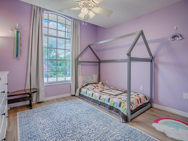 5936 Boggs Ford Rd, Port Orange, FL 32127 - bedroom with wood finished floors, a ceiling fan, and a textured ceiling
