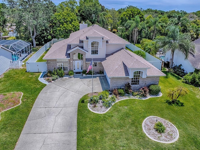 5936 Boggs Ford Rd, Port Orange, FL 32127 - view of front of house with concrete driveway, a chimney, a fenced backyard, and brick siding
