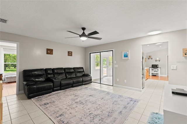 2455 Whooping Crane Dr, De Leon Springs, FL 32130 - living room with light tile patterned floors, a ceiling fan, plenty of natural light, and a textured ceiling