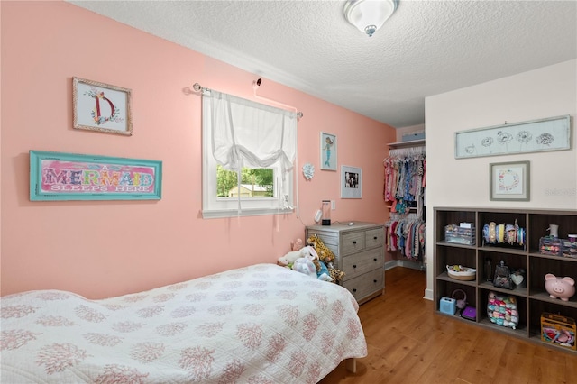 2455 Whooping Crane Dr, De Leon Springs, FL 32130 - bedroom featuring a closet, a textured ceiling, wood finished floors, and a spacious closet