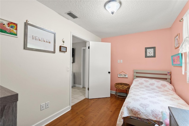 2455 Whooping Crane Dr, De Leon Springs, FL 32130 - bedroom with wood finished floors and a textured ceiling