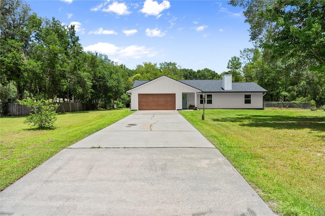 2455 Whooping Crane Dr, De Leon Springs, FL 32130 - view of front facade featuring concrete driveway, a garage, a chimney, board and batten siding, and view of wooded area