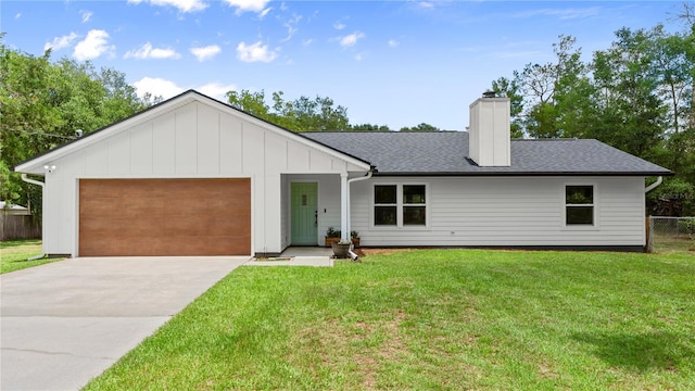 2455 Whooping Crane Dr, De Leon Springs, FL 32130 - view of front facade featuring a chimney, a garage, driveway, a shingled roof, and board and batten siding