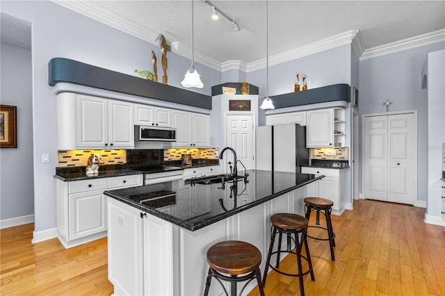 801 Arbor Glen Ct, Ormond Beach, FL 32174 - kitchen featuring stainless steel microwave, open shelves, track lighting, freestanding refrigerator, and white cabinets