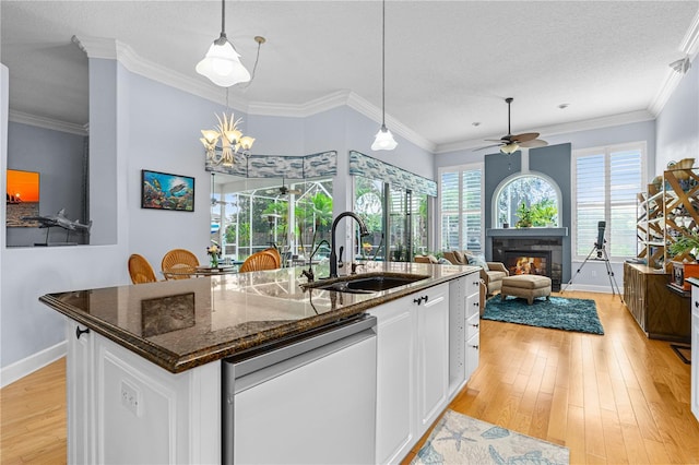 801 Arbor Glen Ct, Ormond Beach, FL 32174 - kitchen with dishwasher, a glass covered fireplace, ceiling fan, white cabinetry, and light wood-type flooring