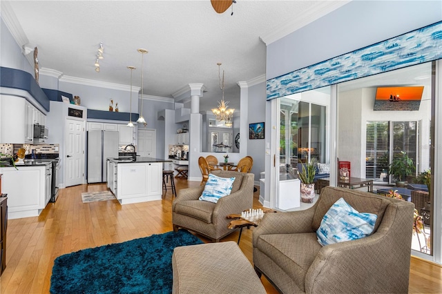 801 Arbor Glen Ct, Ormond Beach, FL 32174 - living room featuring ornamental molding, light wood-style floors, and a chandelier