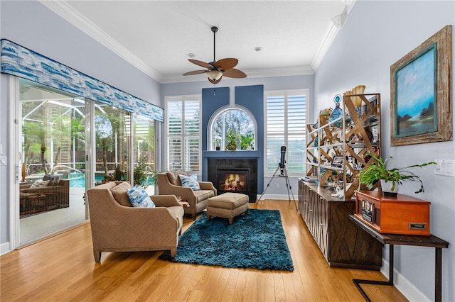 801 Arbor Glen Ct, Ormond Beach, FL 32174 - sitting room with a ceiling fan, light wood-style flooring, a glass covered fireplace, plenty of natural light, and crown molding