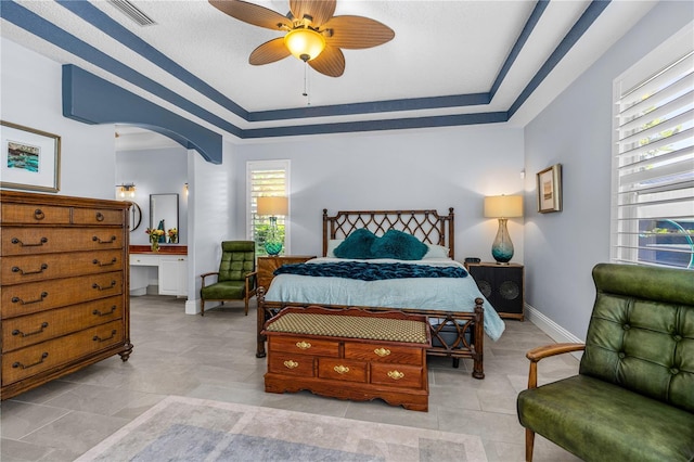 801 Arbor Glen Ct, Ormond Beach, FL 32174 - bedroom with arched walkways, a tray ceiling, and a ceiling fan