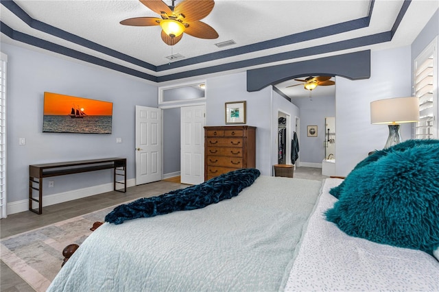 801 Arbor Glen Ct, Ormond Beach, FL 32174 - bedroom with a tray ceiling, a walk in closet, ceiling fan, and a textured ceiling