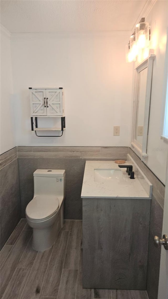 3510 Magnolia Way, Punta Gorda, FL 33950 - half bath with vanity, wood finished floors, a textured ceiling, wainscoting, and tile walls