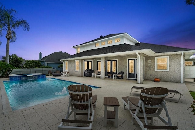 113 Neptune Ave, Ormond Beach, FL 32176 - pool at dusk with a pool with connected hot tub, a patio, and french doors