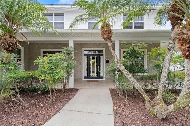 113 Neptune Ave, Ormond Beach, FL 32176 - property entrance with a porch and stucco siding