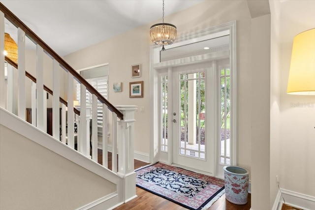 113 Neptune Ave, Ormond Beach, FL 32176 - entrance foyer with wood finished floors, a chandelier, and stairway