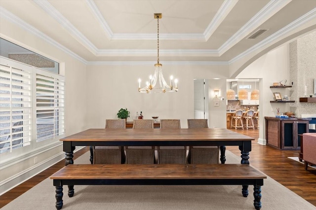 113 Neptune Ave, Ormond Beach, FL 32176 - dining space featuring a tray ceiling, a chandelier, dark wood-style floors, and crown molding