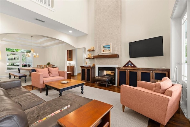 113 Neptune Ave, Ormond Beach, FL 32176 - living room with arched walkways, wood finished floors, a chandelier, crown molding, and a towering ceiling