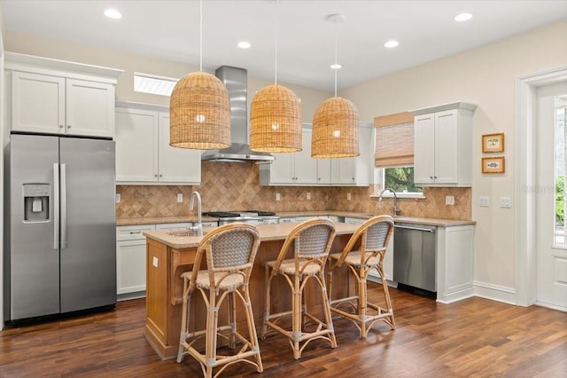 113 Neptune Ave, Ormond Beach, FL 32176 - kitchen with appliances with stainless steel finishes, wall chimney range hood, an island with sink, dark wood-type flooring, and recessed lighting