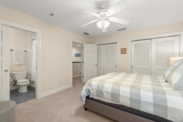 113 Neptune Ave, Ormond Beach, FL 32176 - bedroom with two closets, light carpet, ensuite bath, and a ceiling fan