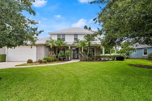 113 Neptune Ave, Ormond Beach, FL 32176 - view of front of home featuring a garage, a front lawn, driveway, a metal roof, and stucco siding