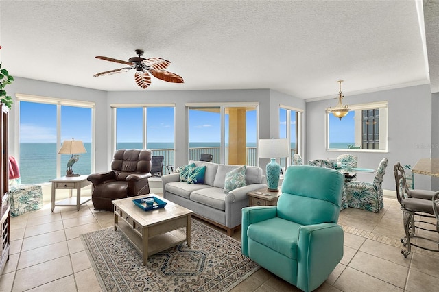 2901 S Atlantic Ave Unit 603, Daytona Beach Shores, FL 32118 - living room with ceiling fan, plenty of natural light, a water view, light tile patterned floors, and a textured ceiling